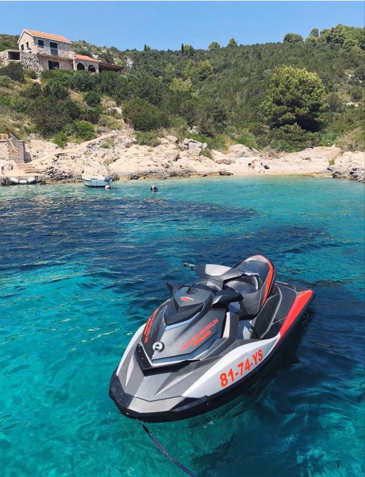 A group of people preparing to board jet skis with an instructor giving directions.