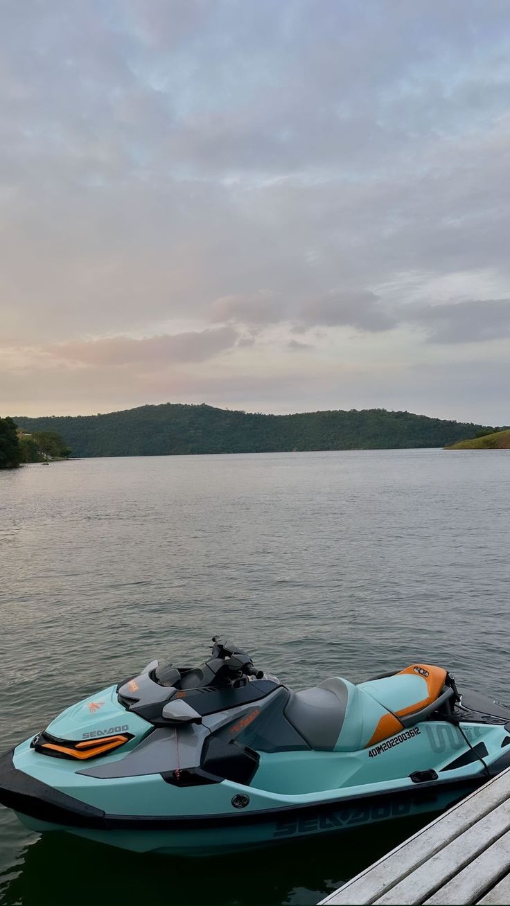 A sunset over the sea in Búzios, with a jet ski parked on the beach in the foreground.